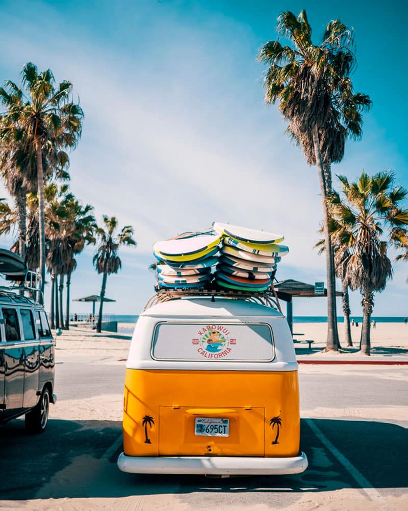 camper van with surf boards on a beach
