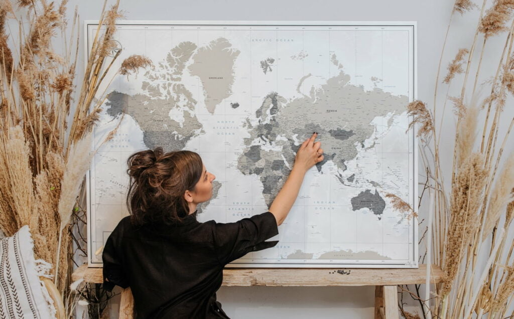 Woman adding pin to a personalized travel map