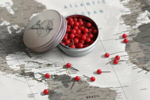 Red travel map push pins in metal case